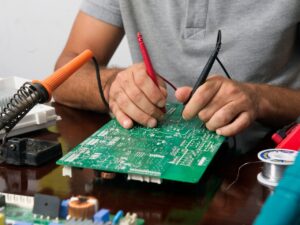 Tech Savvy ATL technician performing micro soldering on a smartphone motherboard